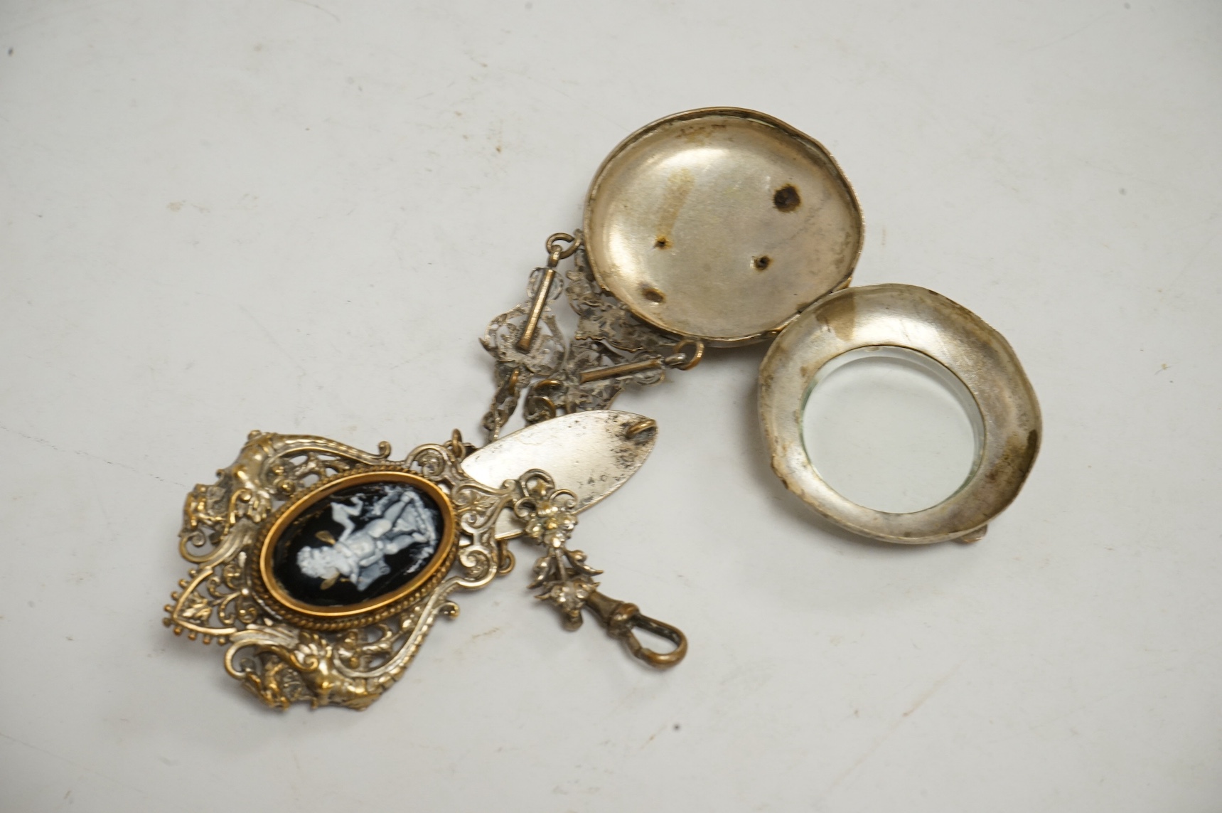 A silver plated chatelaine with two decorative enamel putti cartouche, 15cm long. Condition - parts of the plate has worn
